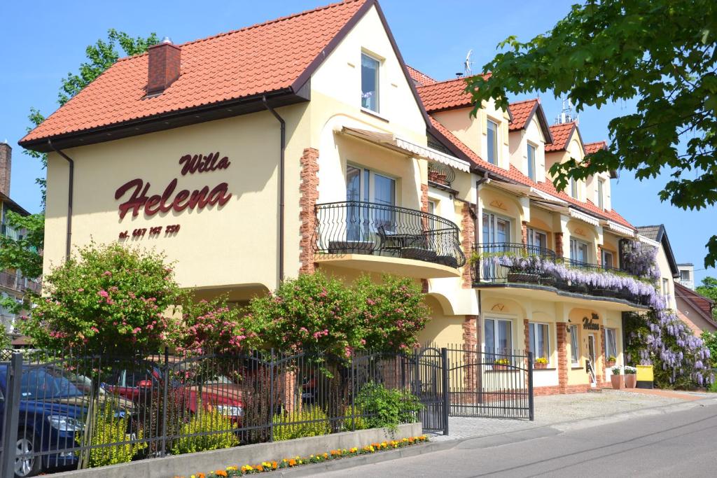 a yellow building with a red roof at Willa Helena in Łeba