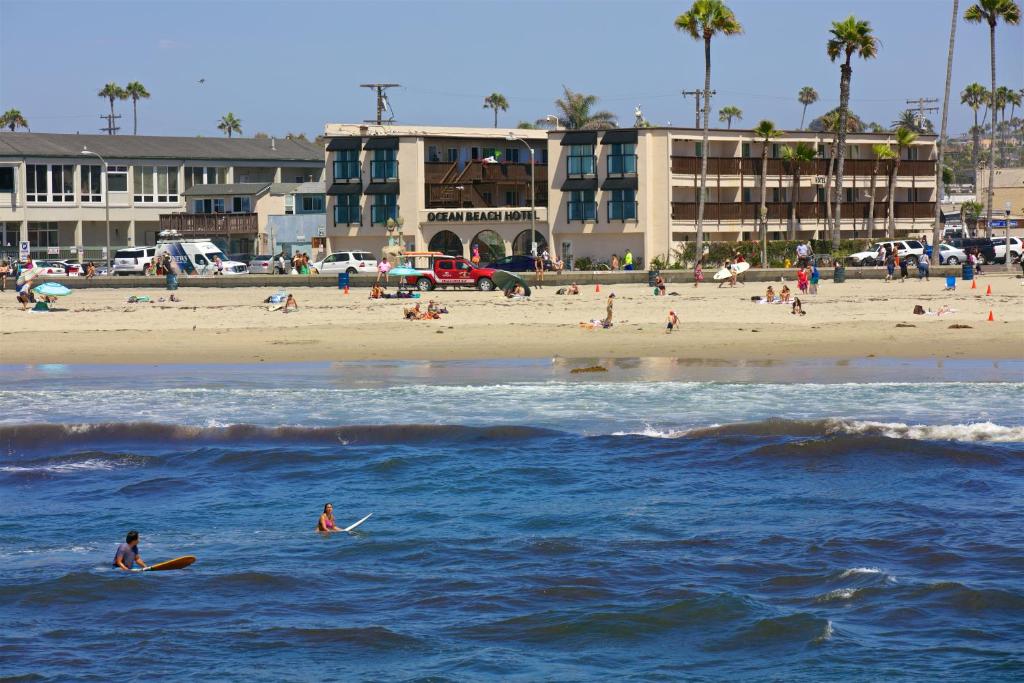 two people on surfboards in the water at a beach at Ocean Beach Hotel in San Diego