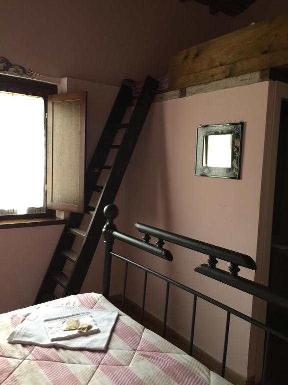 sypialnia z łóżkiem i spiralnymi schodami w obiekcie Agriturismo Casale Loreto w mieście Corchiano