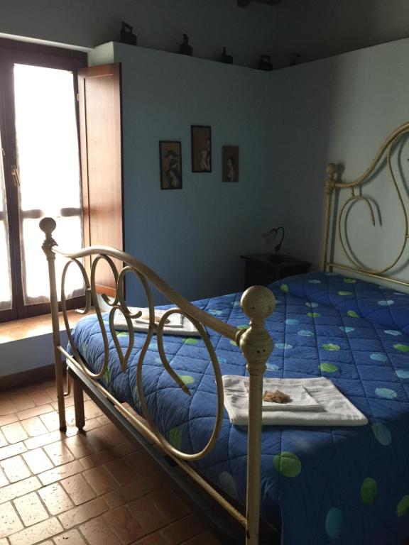 sypialnia z łóżkiem z niebieską kołdrą w obiekcie Agriturismo Casale Loreto w mieście Corchiano