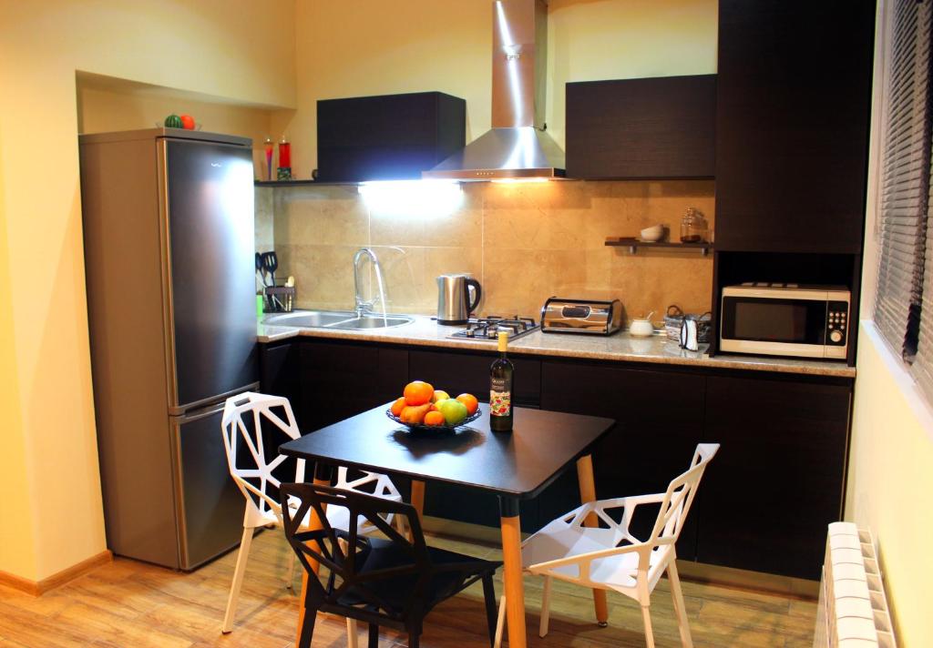 una cucina con un tavolo con una ciotola di frutta sopra di Yango Apartment a Tbilisi City