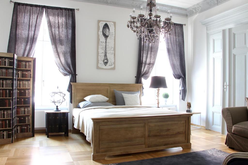 a bedroom with a large bed and a chandelier at Leon Apartments in Leipzig