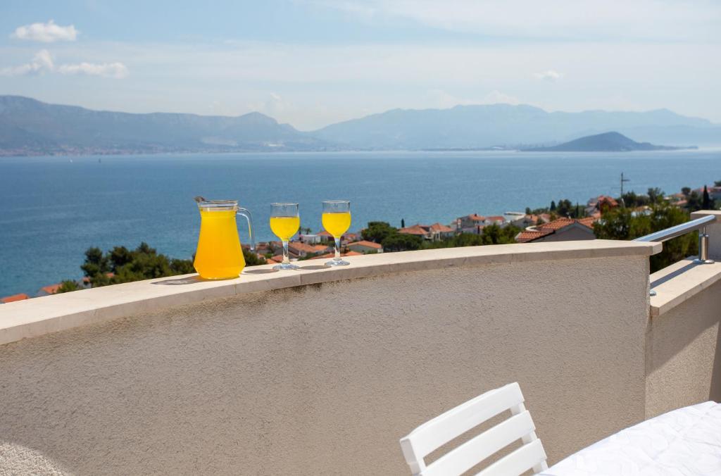 dos vasos de vino amarillo sentados en una cornisa en Apartments in Villa TOP TROGIR, en Trogir