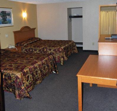 um quarto de hotel com duas camas e uma mesa em South Bay Motel em Copiague