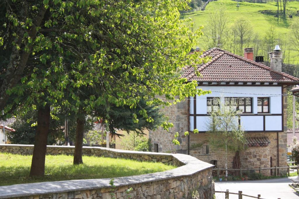 a house with a stone wall in front of it at Cal Xabú in Cuérigo
