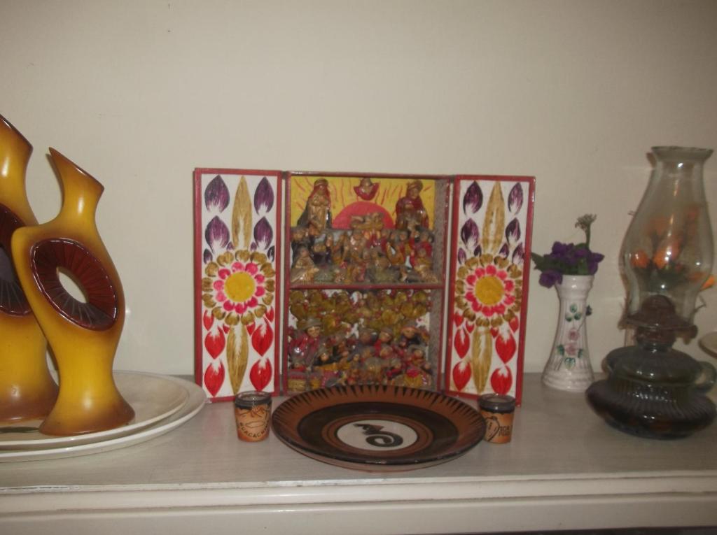 a shelf with a plate and vases on a table at Hospedaje Casa Viru in Lima