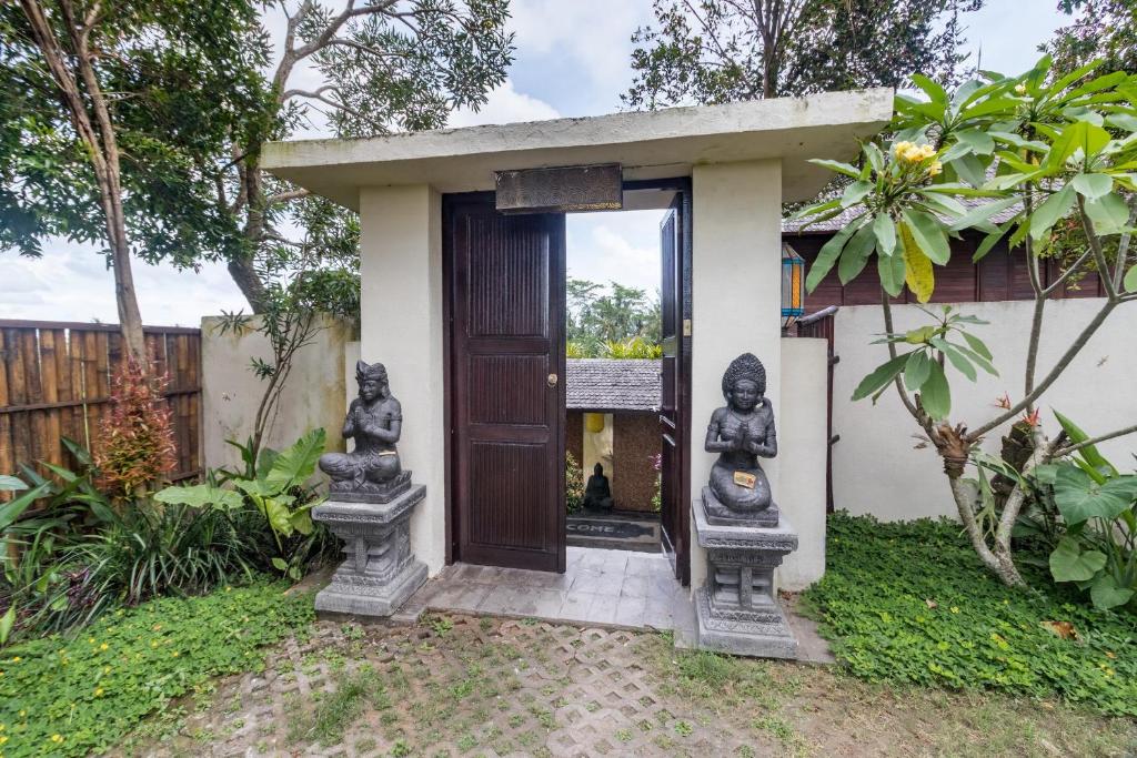 a small house with statues outside of it at Villa Padi Menari in Ubud