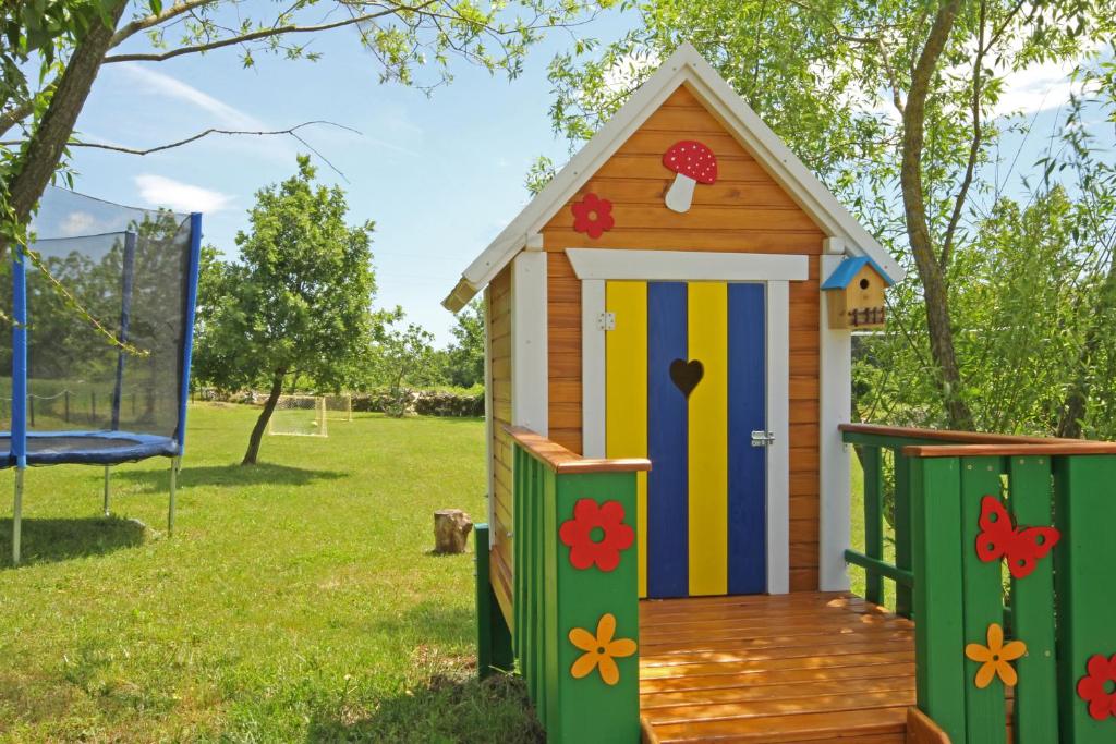 a wooden play house with a colorful door at Villa Stari Punat in Sveti Petar u Šumi