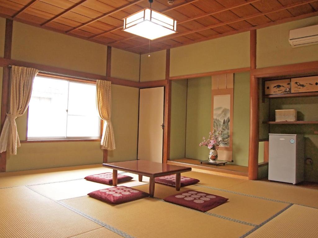 a living room with a table and a window at Kikuya Ryokan in Tonosho