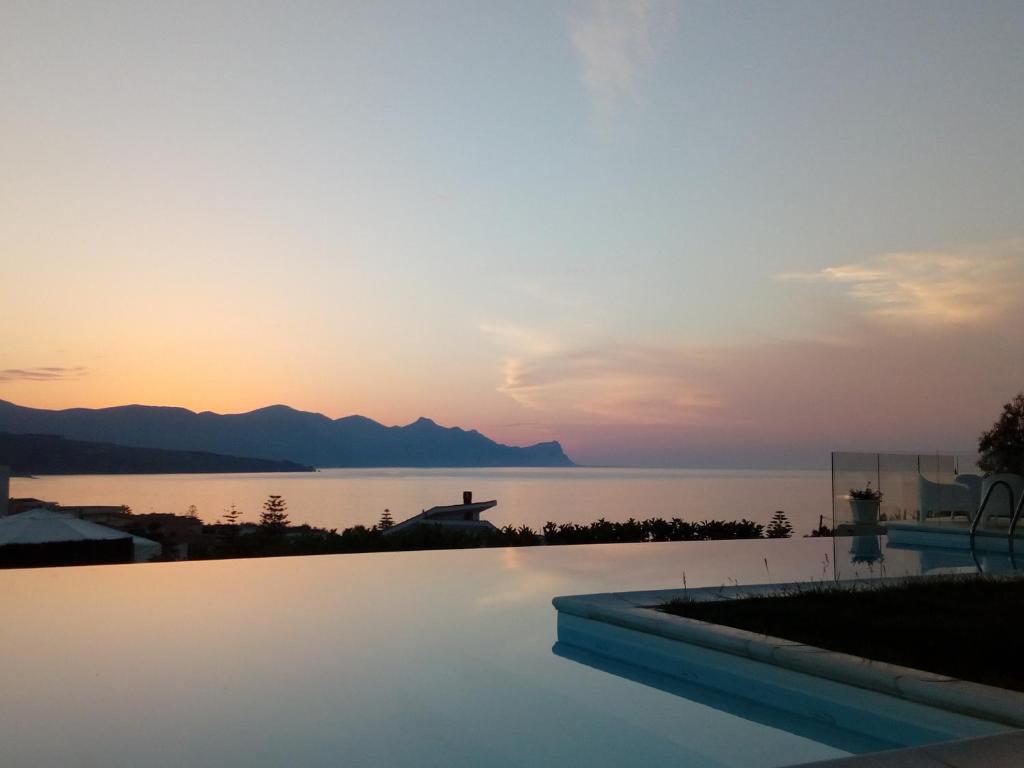 a swimming pool with a view of the ocean at sunset at Villa Piscina sul Mare in Alcamo Marina