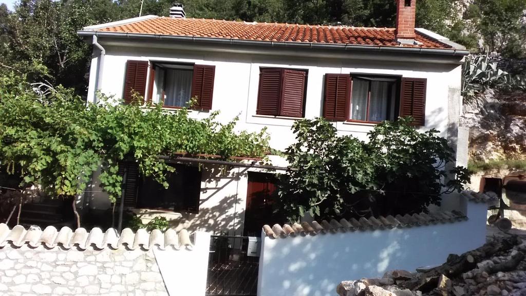 uma casa branca com uma cerca branca em Apartman Legac em Starigrad