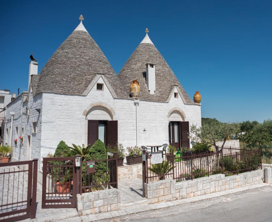 une église blanche avec un toit pointu dans l'établissement Grandi Trulli Bed & Breakfast, à Alberobello