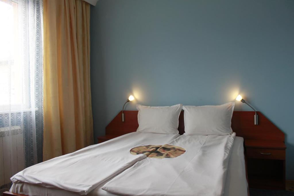 Una cama con dos luces encima. en Guest House Tabakovi en Velingrado