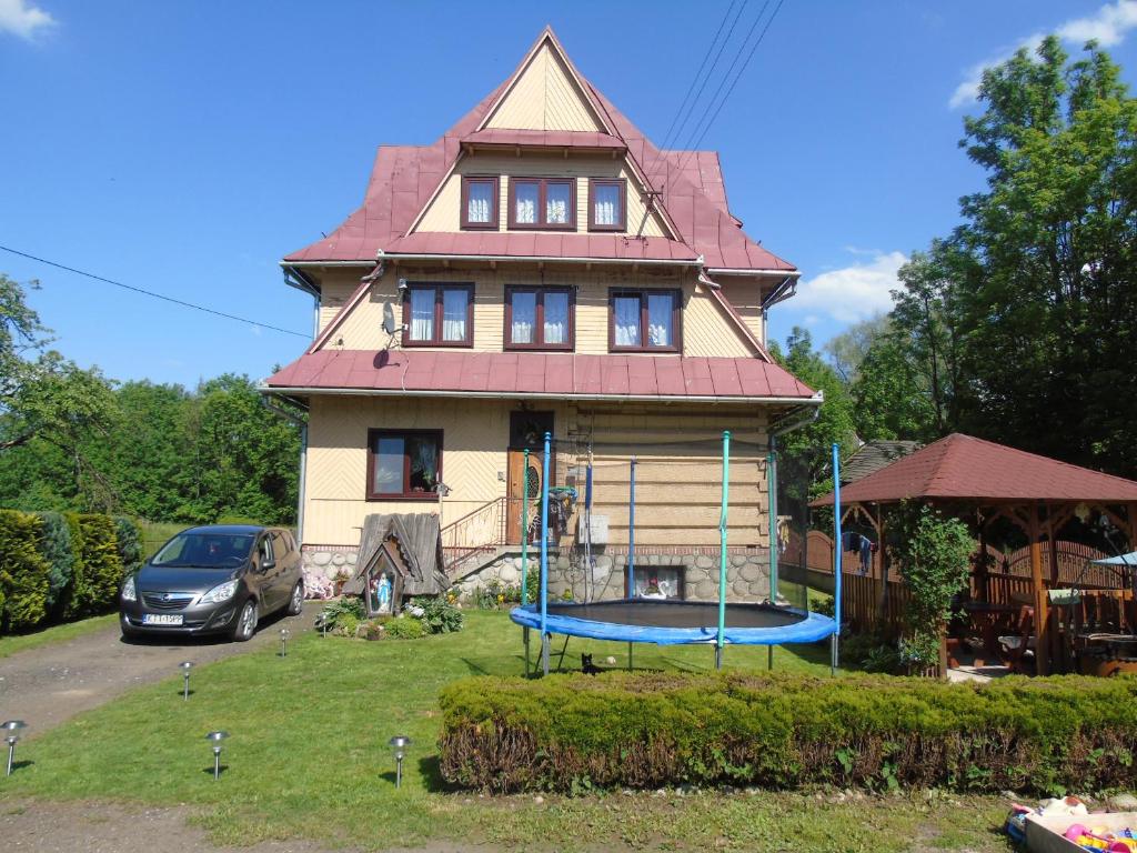 ein Haus mit einem Spielplatz davor in der Unterkunft Pokoje Gościnne u Marysi in Białka Tatrzańska