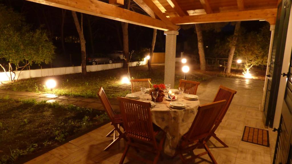 - une table et des chaises sur la terrasse la nuit dans l'établissement Casa Naiadi, à Valledoria