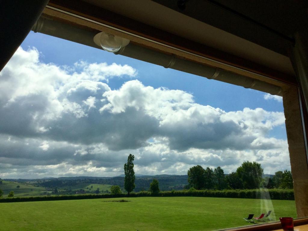 a view of a field from a window at Escale en Charolais Brionnais in Saint-Julien-de-Civry