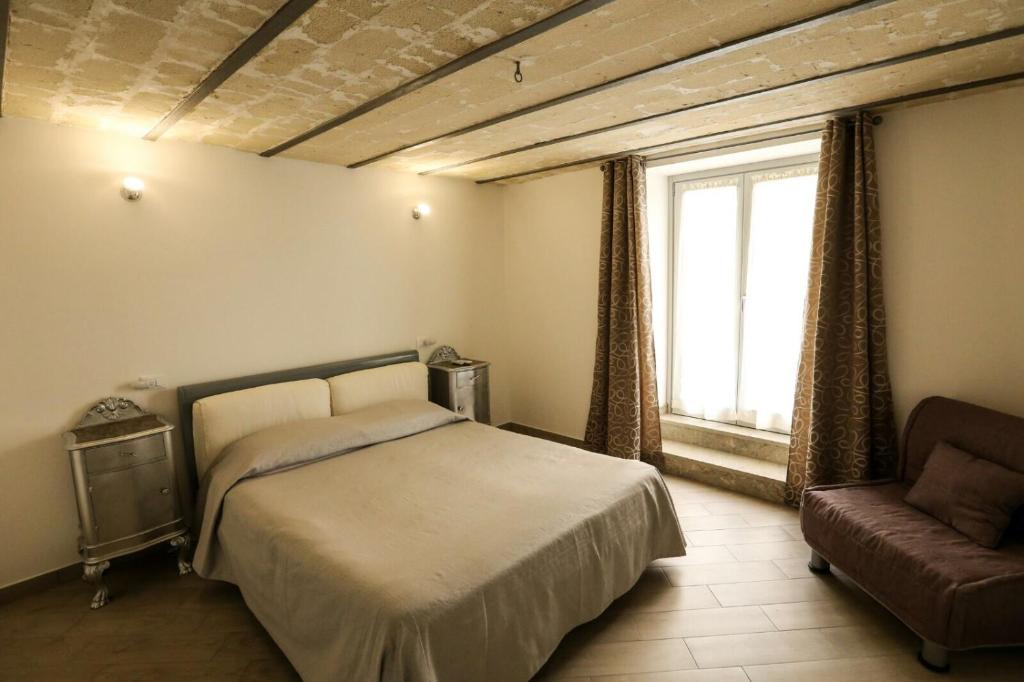 トラーパニにあるAffittacamere San Lorenzoのベッドルーム1室(ベッド1台、ソファ、窓付)