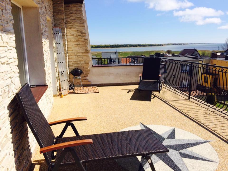 a patio with two chairs and a bench on a balcony at Apartamenty na Nadmorskiej in Władysławowo