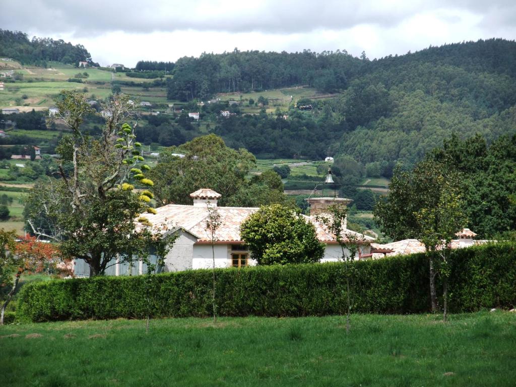 una casa en un campo con un seto en Pazo Da Cruz, en Villarmayor