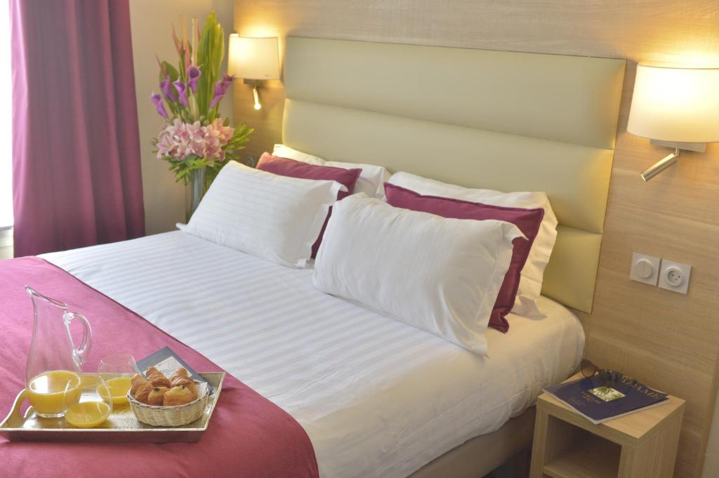 a hotel room with a bed with a tray of food on it at Unic Renoir Saint Germain in Paris