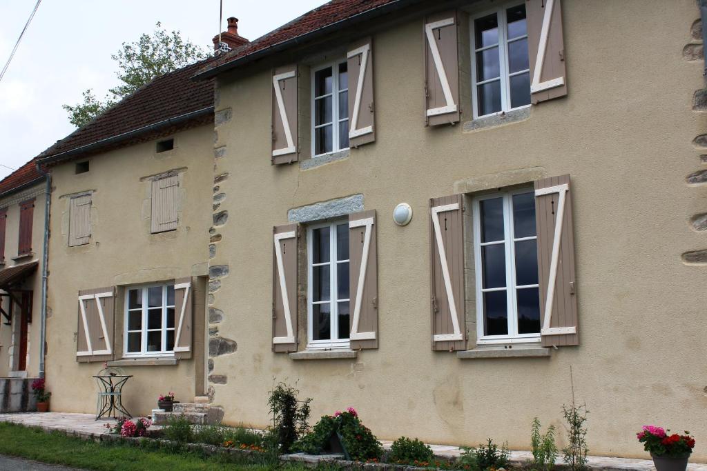 een huis met ramen en luiken erop bij Bernadette in Chouvigny