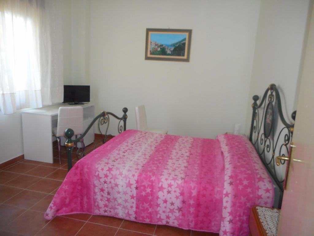 a bedroom with a pink bed and a desk at B&B Stella Marina in Soverato Marina