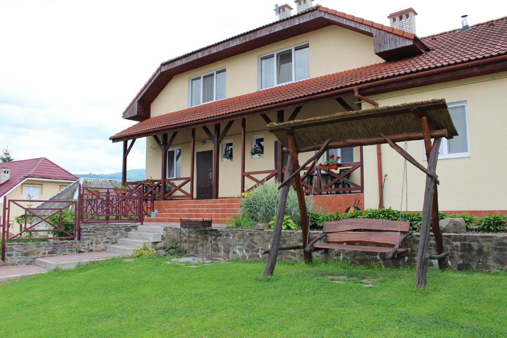 ein Haus mit einer Bank davor in der Unterkunft Panorama Townhouse in Poljana