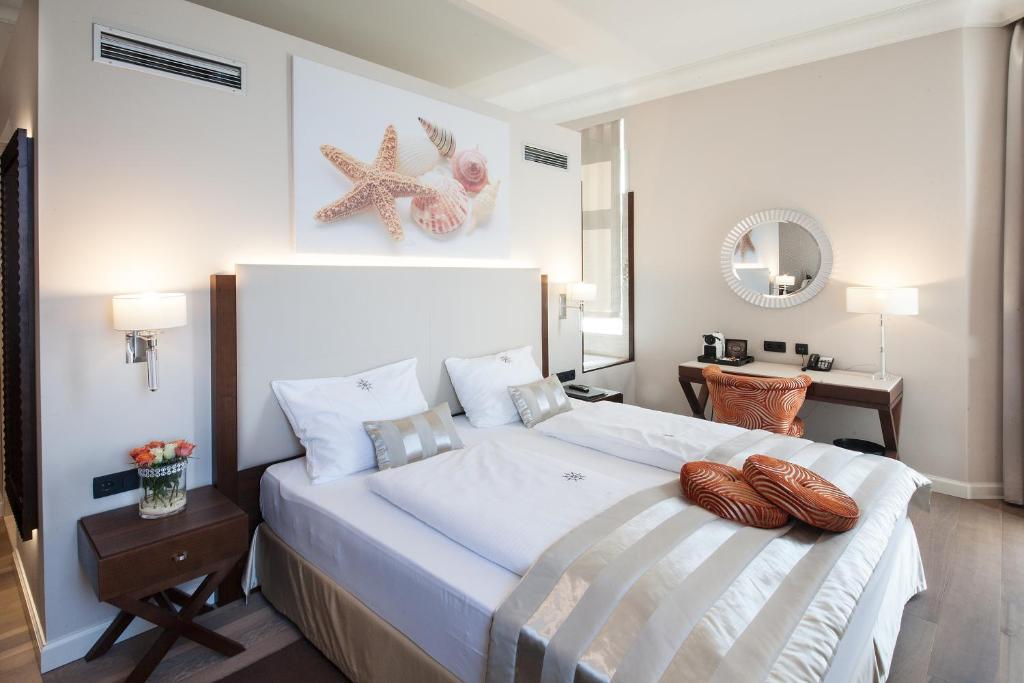 ein Schlafzimmer mit einem großen weißen Bett mit zwei Seilen darauf in der Unterkunft Boutique Hotel Adria in Wels