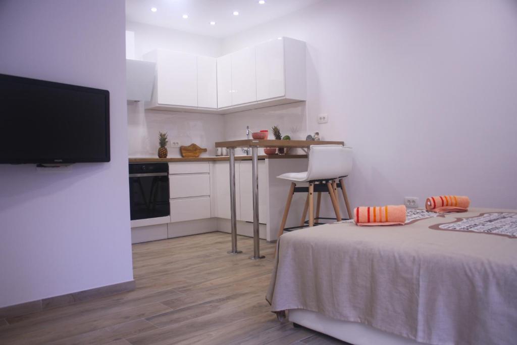 a room with a bed and a kitchen with white cabinets at M-Dream, in heart of Split in Split