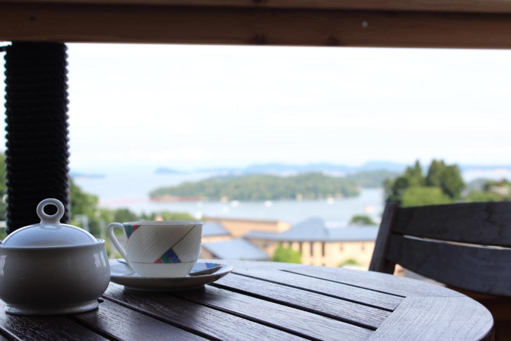um bule de chá e uma chávena numa mesa de madeira em Matsushima Petit Hotel Bistro Abalon em Matsushima