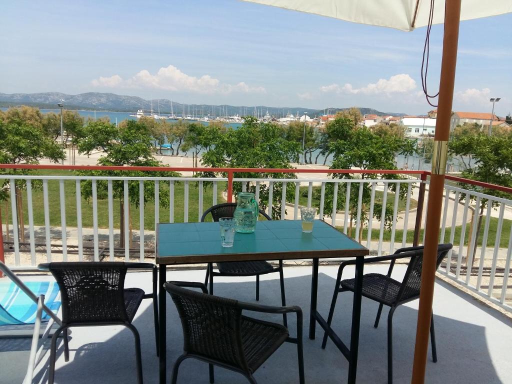 a table and chairs on a balcony with a view at Basil Apartments and Rooms in Betina