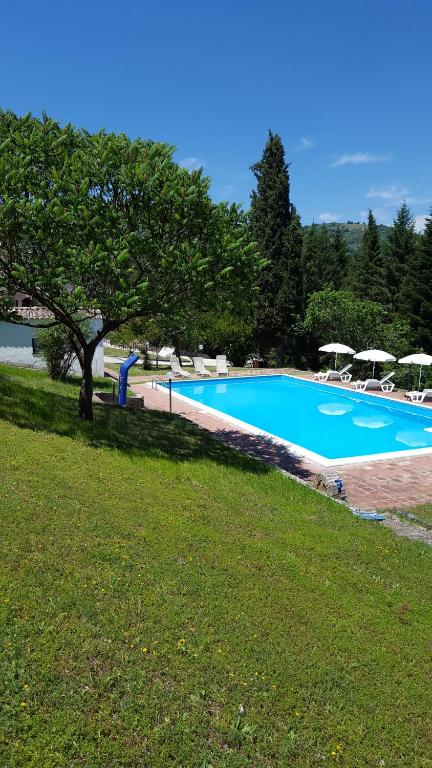 ein großer Pool mit Sonnenschirmen in einem Park in der Unterkunft Piccoli Sogni in Valfabbrica