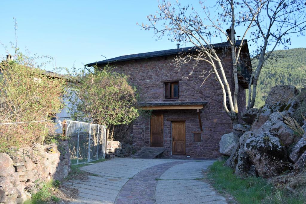 a stone house with a door and a stone driveway at El Corralet de Cal Tonico in Llagunes