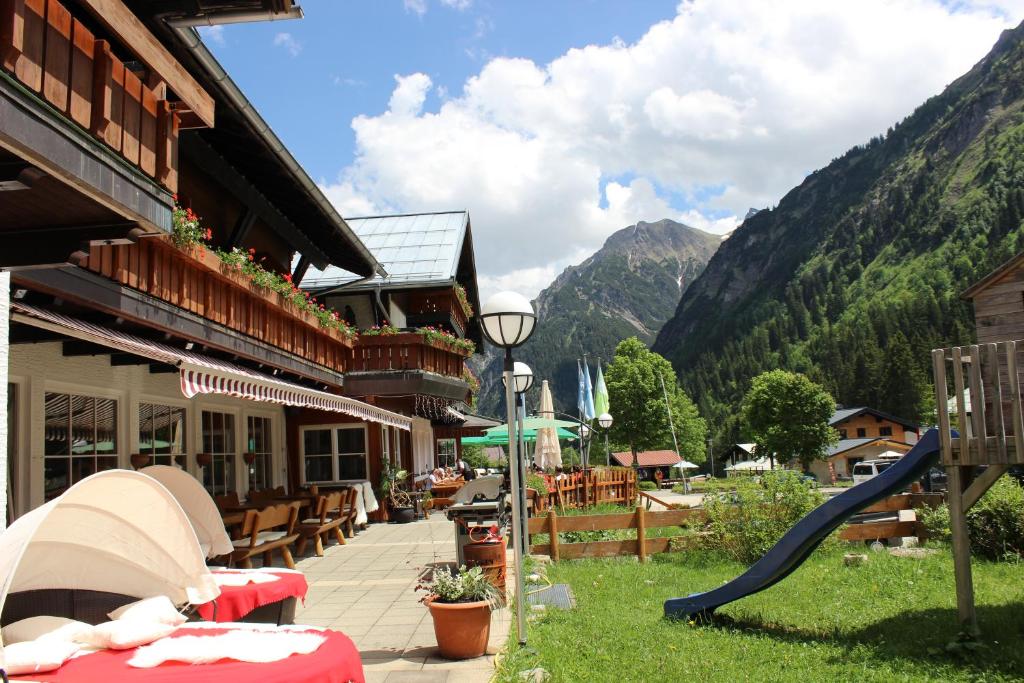 un complexe avec une aire de jeux et un toboggan dans l'établissement Alpenhotel Widderstein, à Mittelberg