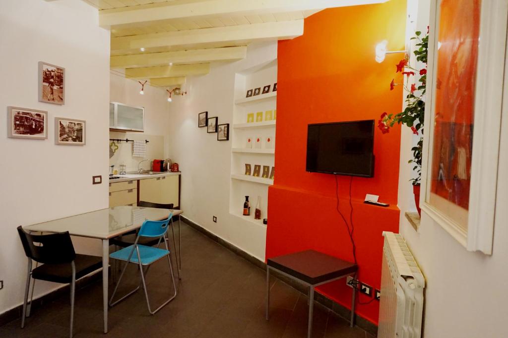 a dining room with a table and chairs and a tv at Studio Apartment Vicolo Lavandai in Milan