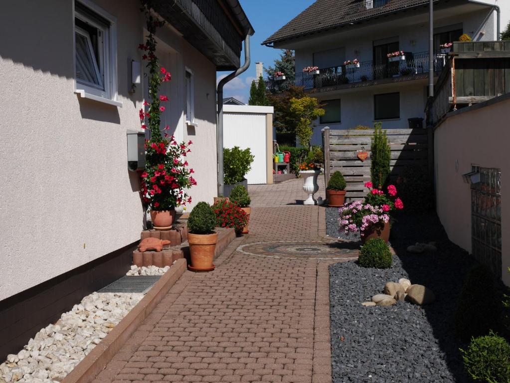 a brick walkway with potted plants on the side of a house at Ferienwohnungen Forneck in Zeltingen-Rachtig