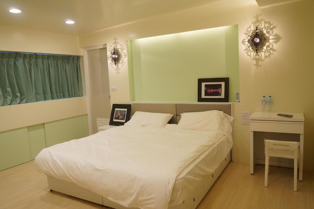 1 dormitorio con cama blanca y espejo en Lai Yi Ke B&B, en Dongshan