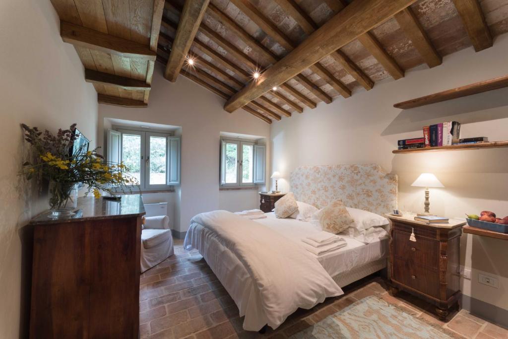 Un dormitorio con una cama grande en una habitación con techos de madera. en Tenuta Santo Pietro, en Pienza