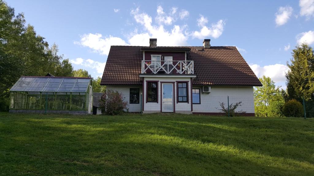 a small white house with a large grass yard at Mäe Farm in Rõuge