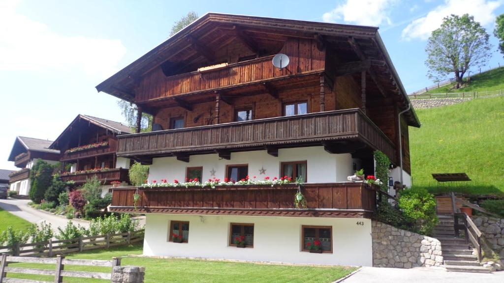 a wooden house with a balcony on a hill at Haus am Sunnfeld in Alpbach