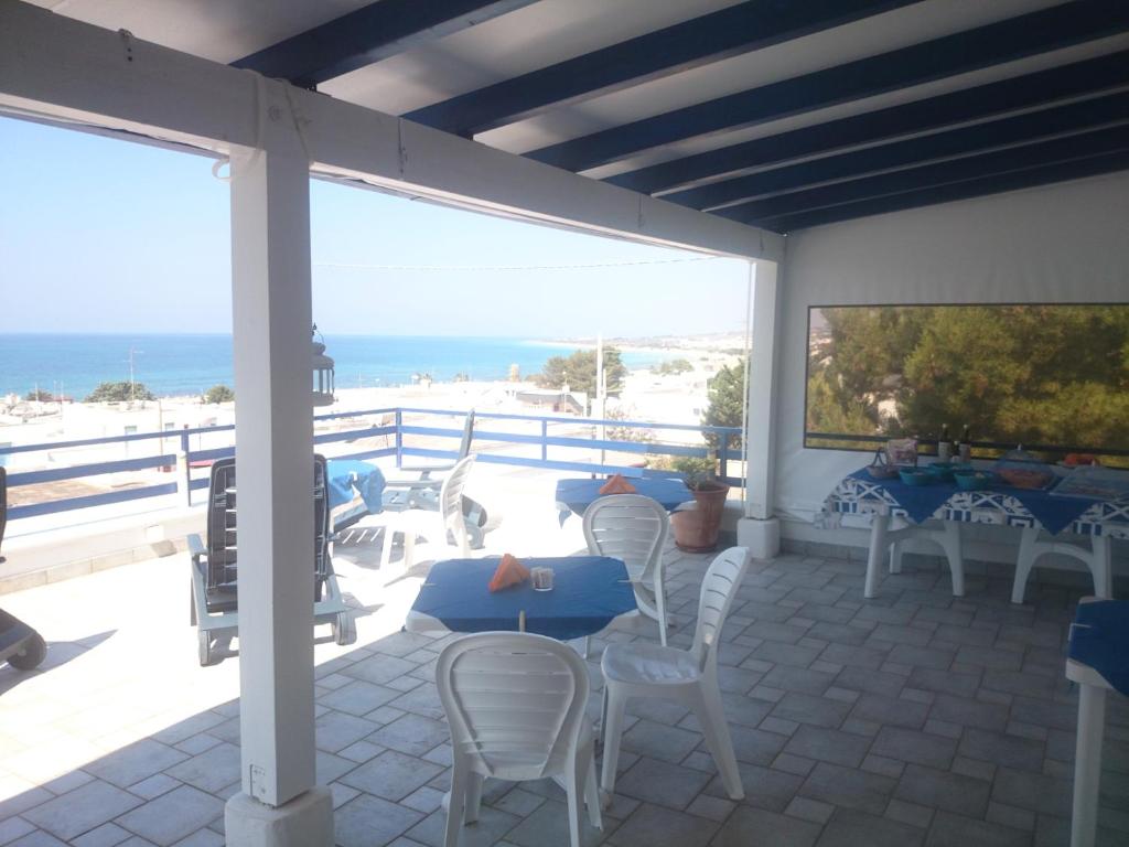 a patio with tables and chairs and a view of the beach at Bed and breakfast Delfino Blu in Torre Vado