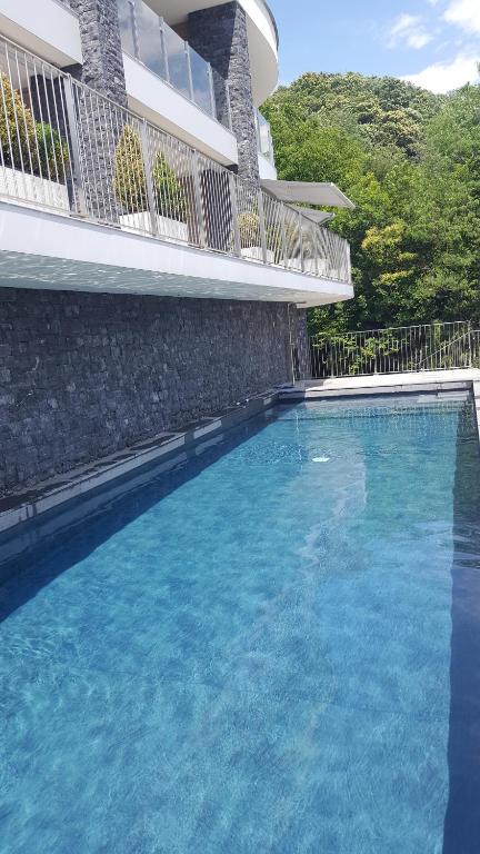 a large blue swimming pool next to a building at Como Lake Residenza Armonia in Gera Lario