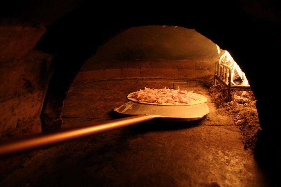 a pizza is being cooked in a brick oven at Penzion Vanessa in Lipova Lazne