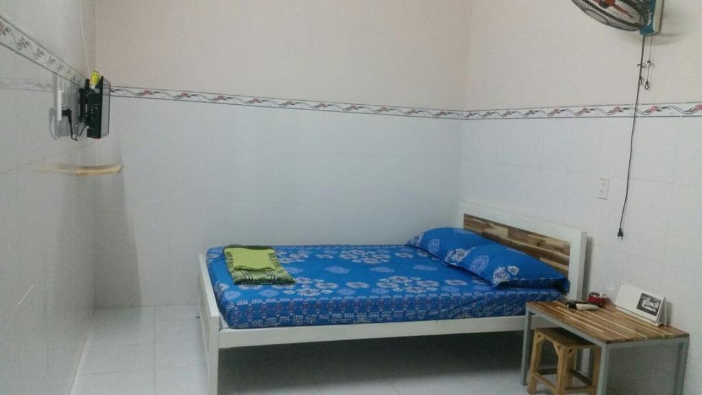 a small bedroom with a bed and a table at Misa Guesthouse in Dien Khanh
