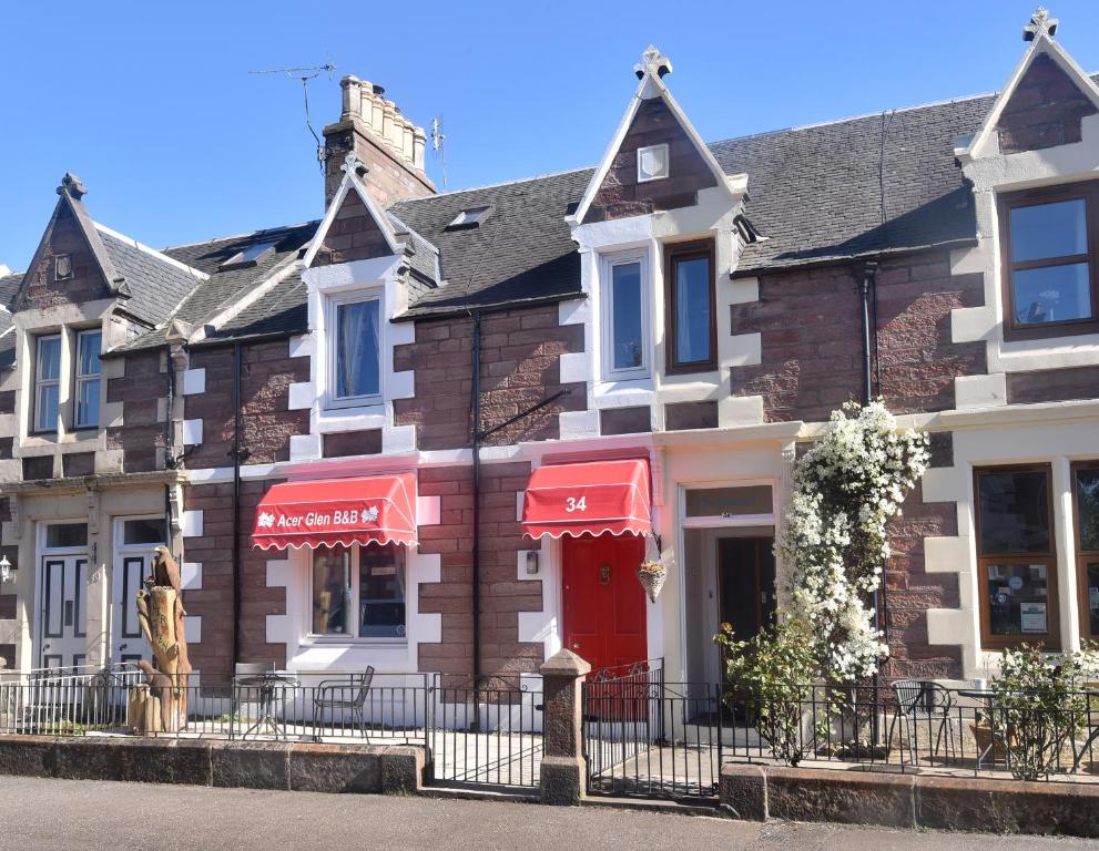 a row of houses with red umbrellas on a street at Acer Glen B&B in Inverness