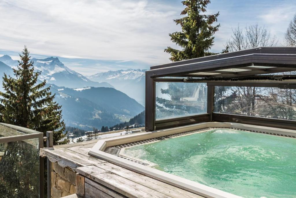 a hot tub with a view of mountains at Hôtel Le Grand Chalet in Leysin