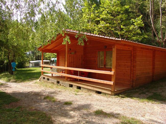 una pequeña cabaña de madera en medio de un campo en Camping Ribera del Ara, en Fiscal