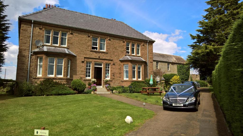 un coche aparcado frente a una casa de ladrillo en Hay Farm House en Ford