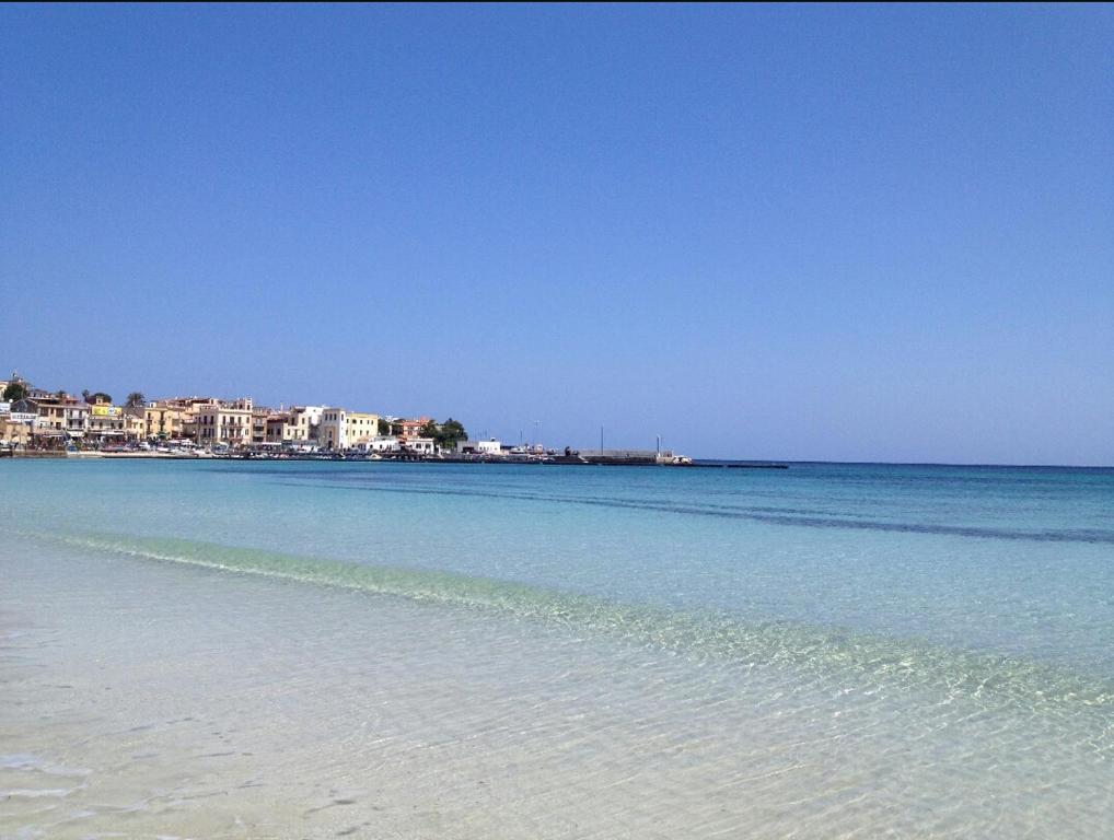 パレルモにあるVilla Pinellaの青い海と建物を背景にしたビーチ
