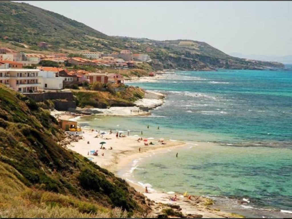 eine Gruppe von Menschen an einem Strand in der Nähe des Ozeans in der Unterkunft Apartment Arianna 150mt from beach in Castelsardo